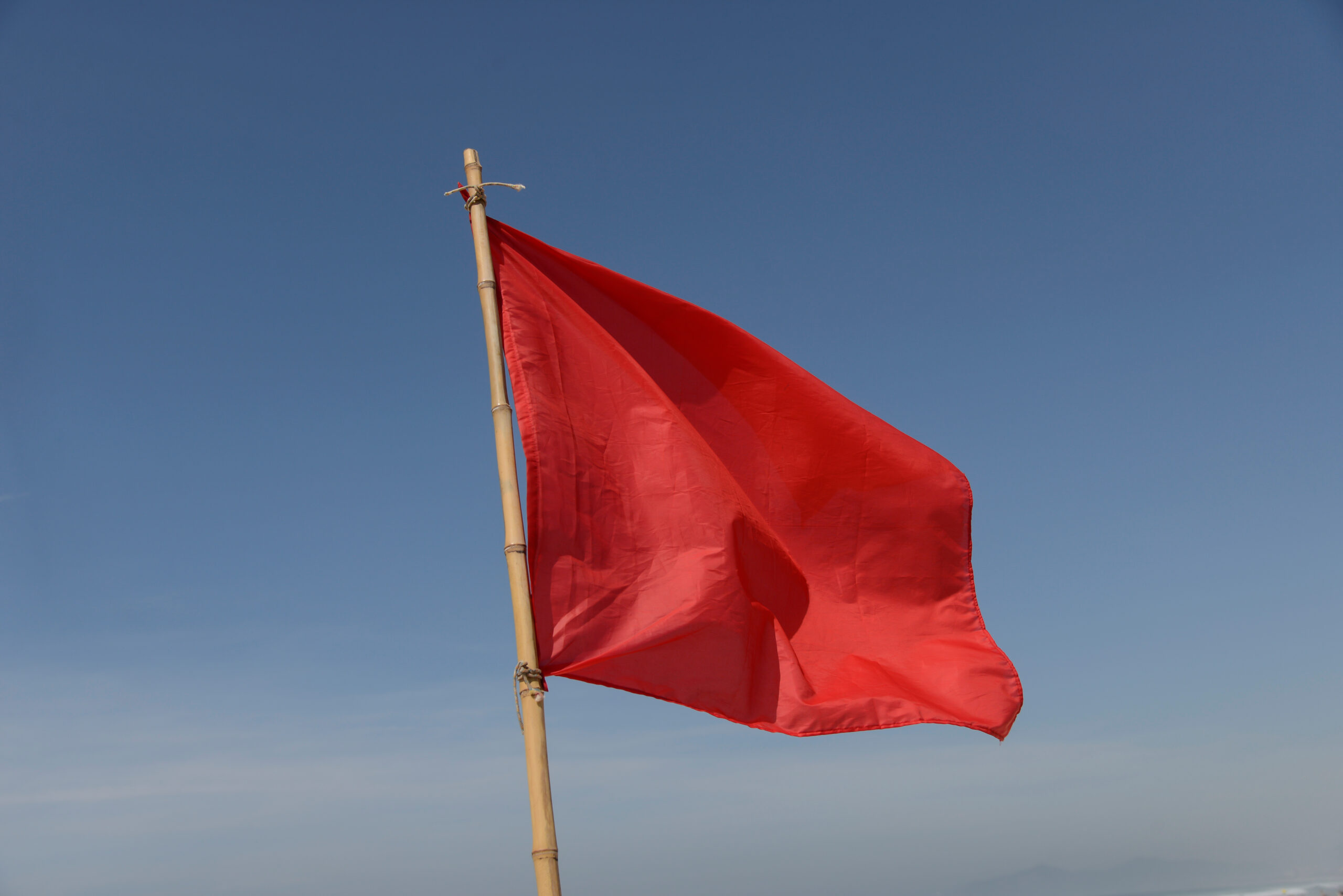 Red flag against sky background